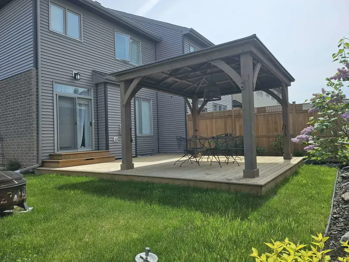 Install a pressure-treated wood deck with cedar pergola for backyard patio dining area