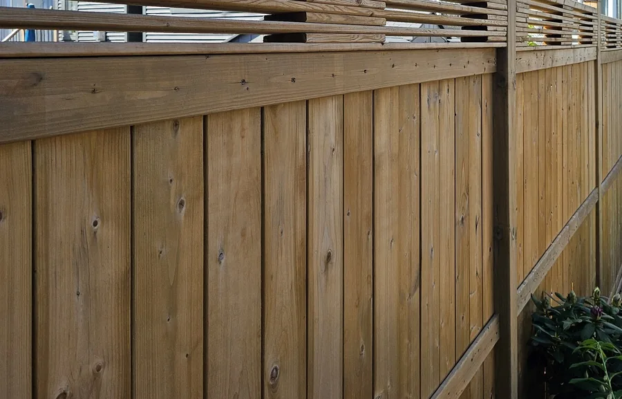 Close view of pressure-treated lumber with a capped top rail on one of our builds