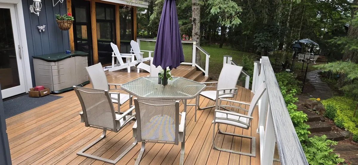 Cedar deck with Adirondack chairs and a hot tub corner, designed and built by XP Decking