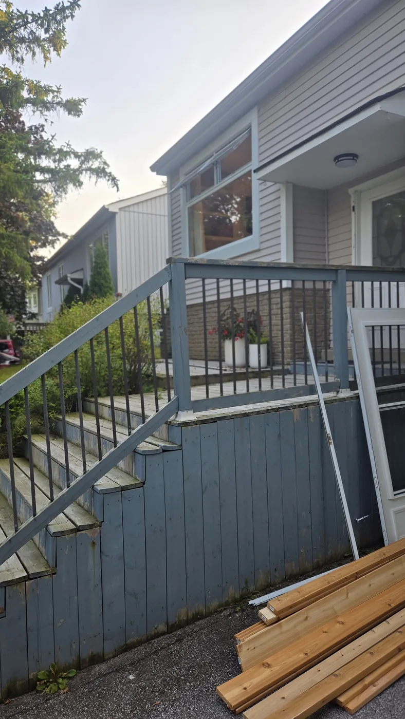 Weathered deck stairs with a painted metal railing, photographed before XP Decking rebuilt them