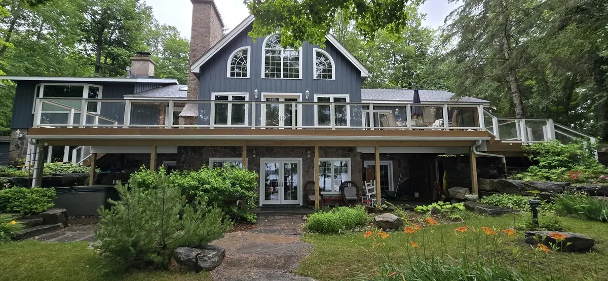 Wraparound cedar deck on a stone cottage, built by XP Decking