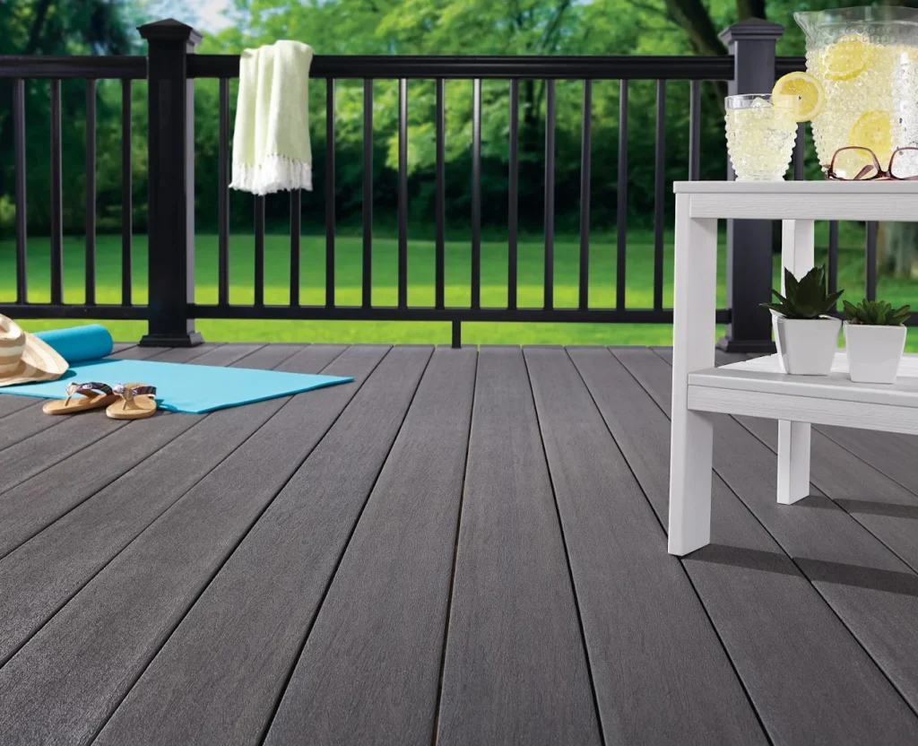 Stylish dark composite decking with black railing and summer decor in Ontario backyard, ideal for relaxation or yoga